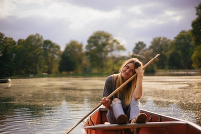坐在船上拿着桨的女人